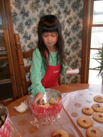 Kasen putting cookies in tins